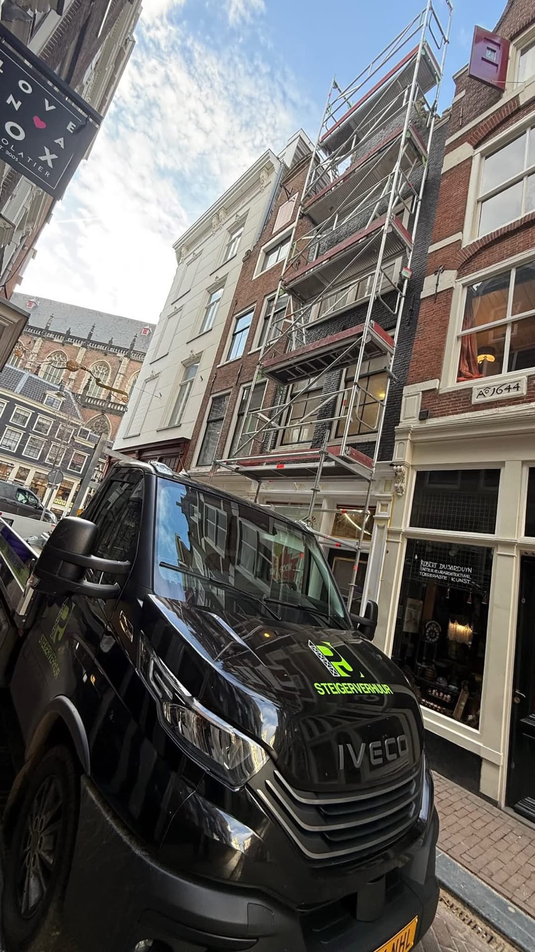 PJ Steigerverhuur bedrijfsbus bij gevelsteiger in Amsterdamse binnenstad