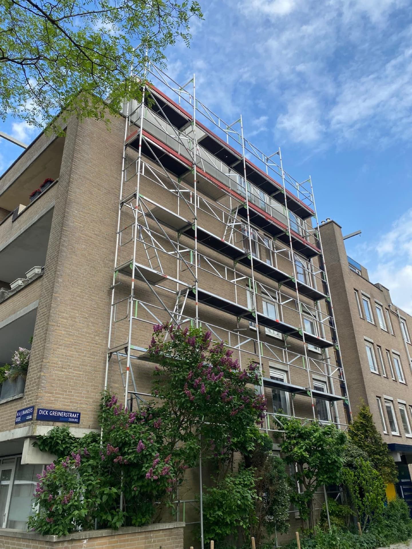 Stalen systeemsteiger voor gevelrenovatie van flatgebouw met balkons